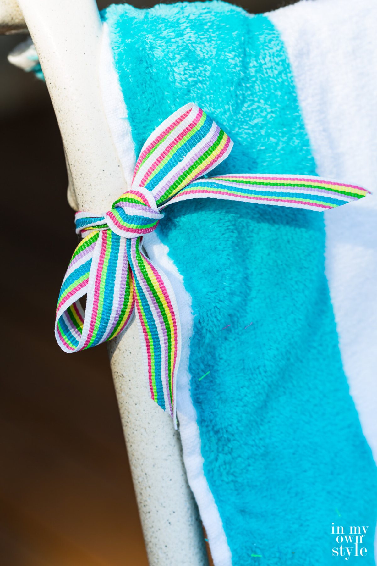 How to attach a beach towel to a chair to make an easy no sew slipcover for outdoor furniture.