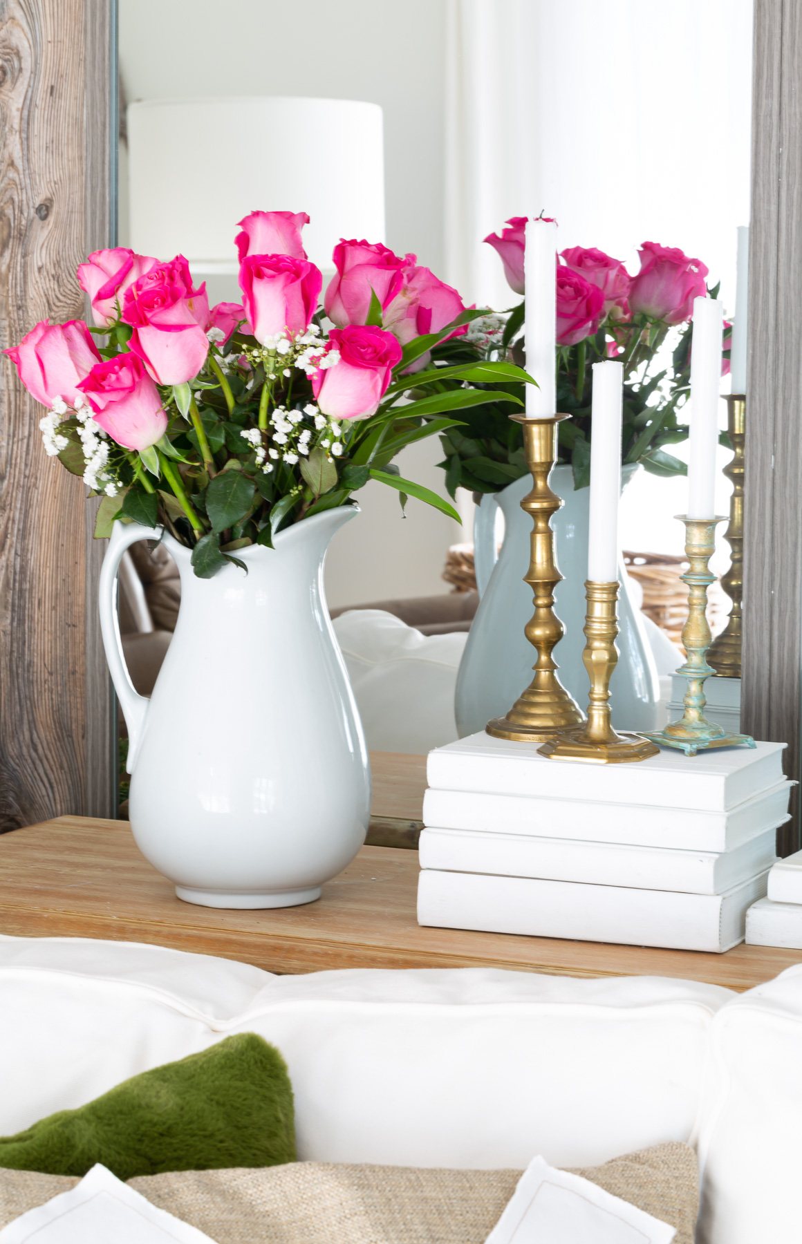 pink roses in a white vase on a sofa table
