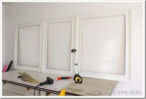 Empty-frames lined up along wall to figure out placement.