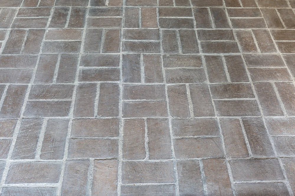 A section of floor showing the completed whitewashing over the brick and grout floor.