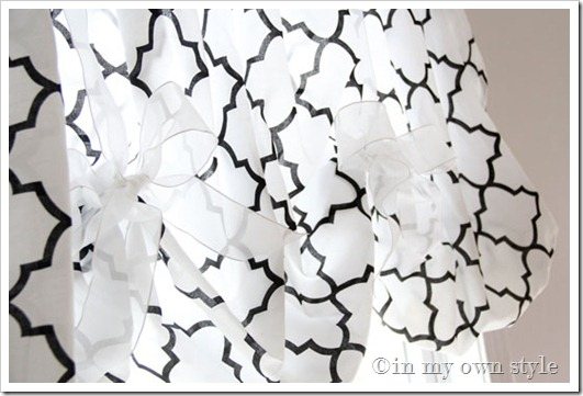 Black and white patterned No sew balloon style window valance made with a fitted sheet tied on rod with sheer white ribbon.