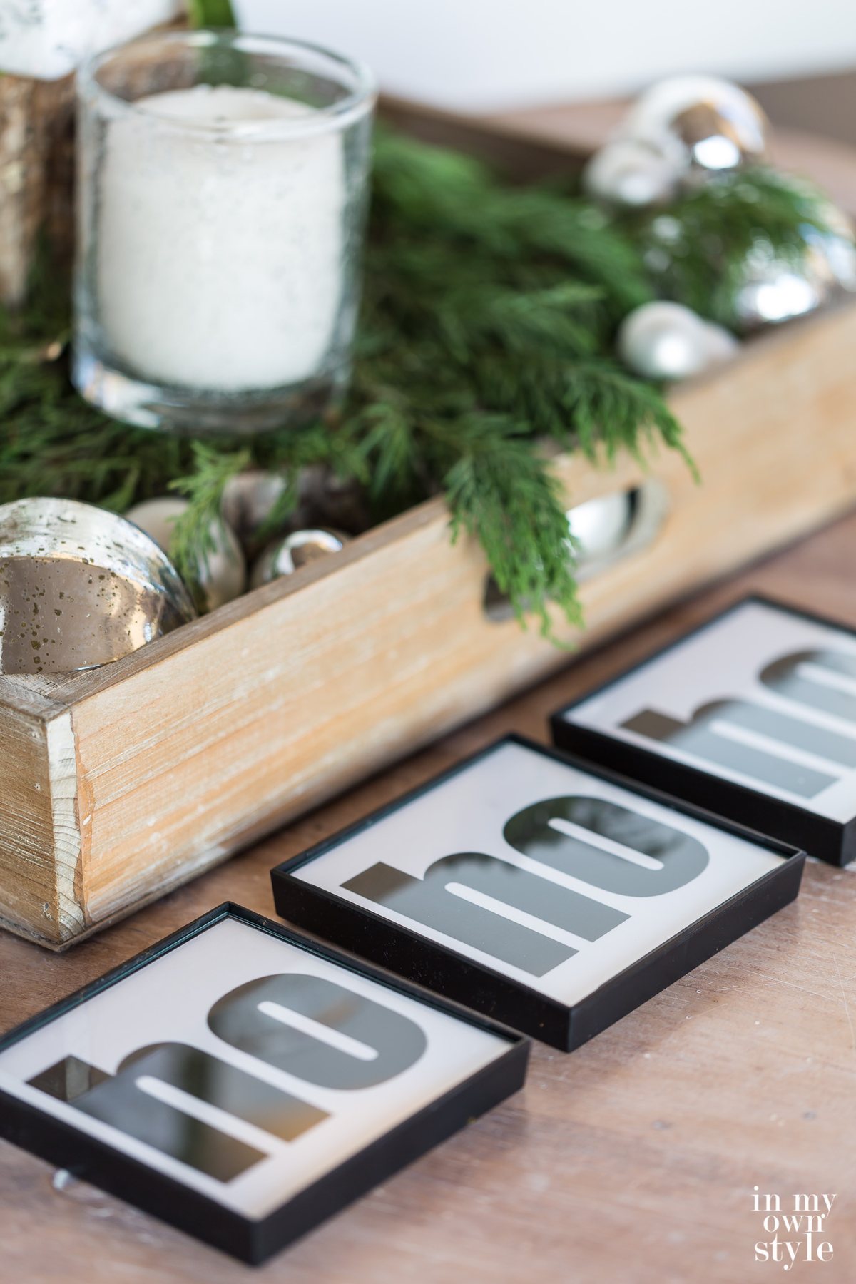 Ho ho ho Holiday drink coasters on a table decorated for Christmas.