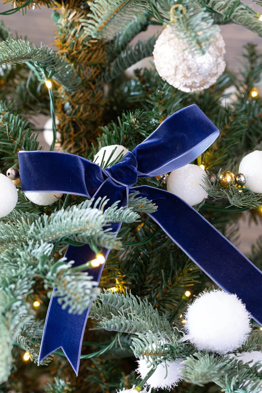 blue velvet bow on a King of Christmas artificial Christmas tree.