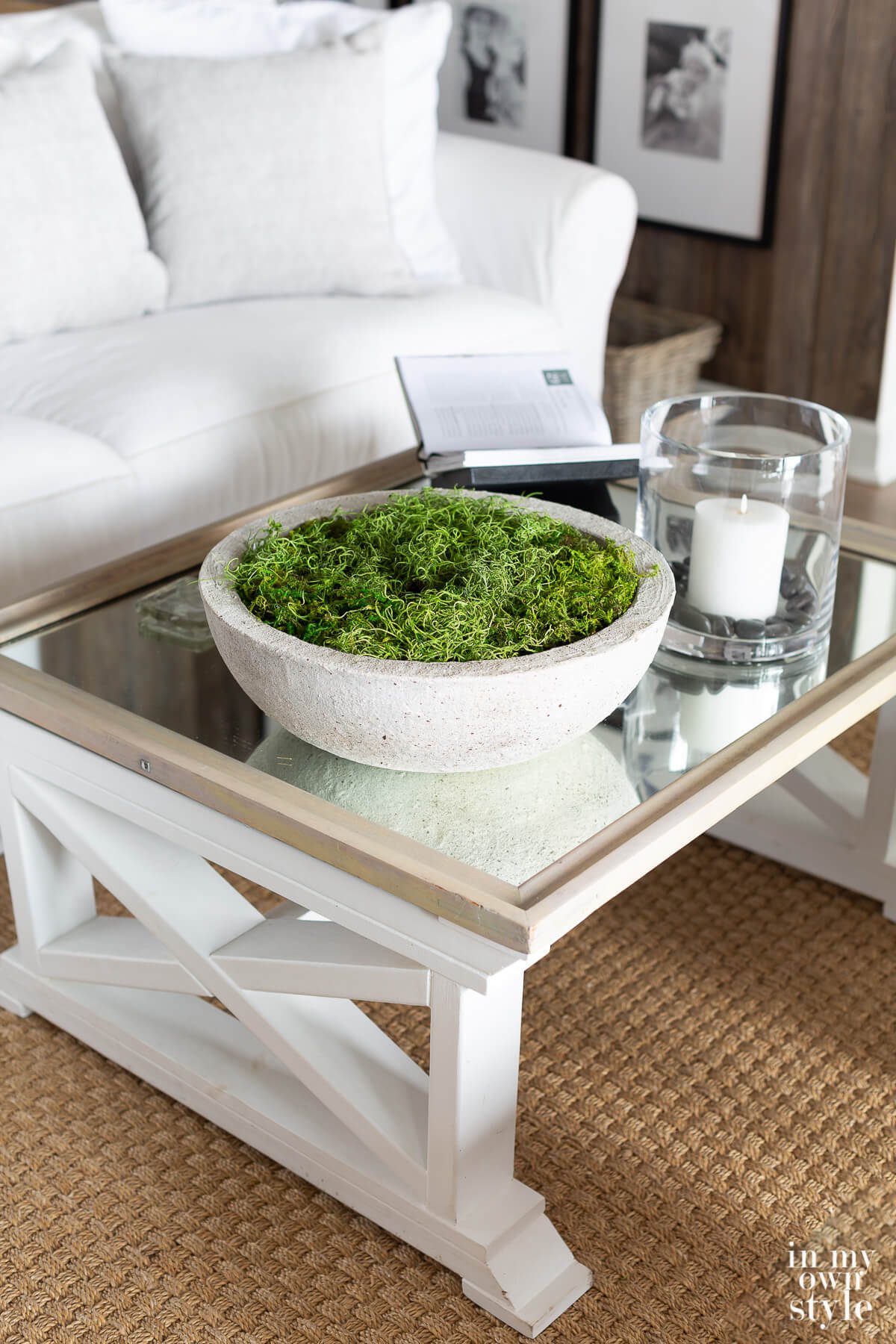 Mirrored top coffee table with concrete bowl filled with moss on top.