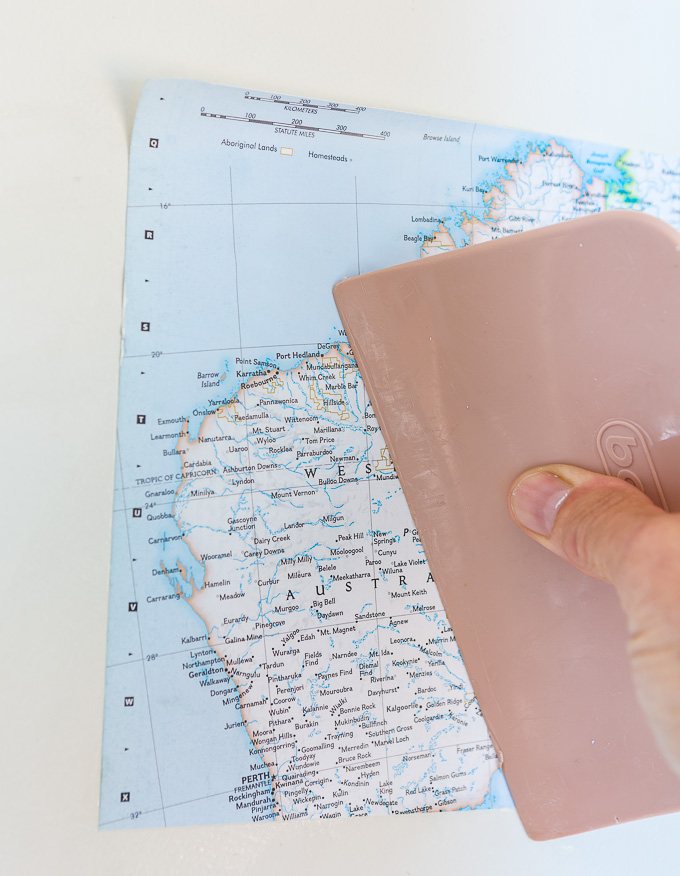 DIY map wallpaper step by step tutorial that shows how to remove wrinkles that may appear when applying maps and or paper to walls