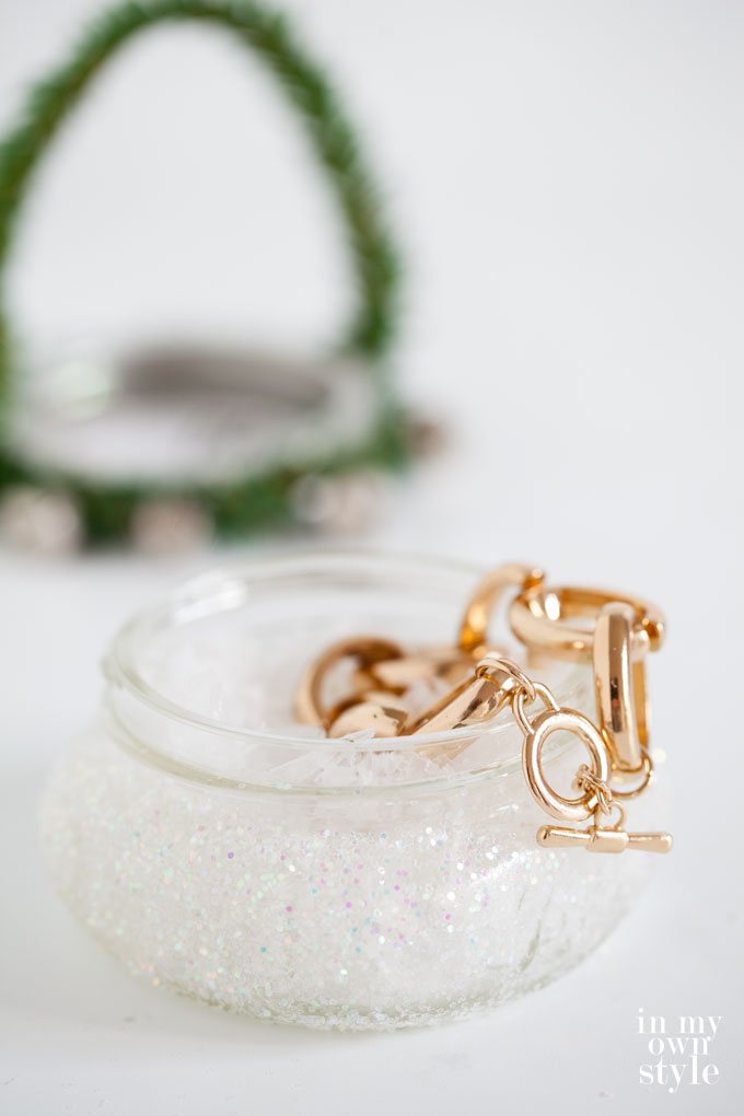 Pint sized Ball jar filled with fake snow and a gold link bracelet.