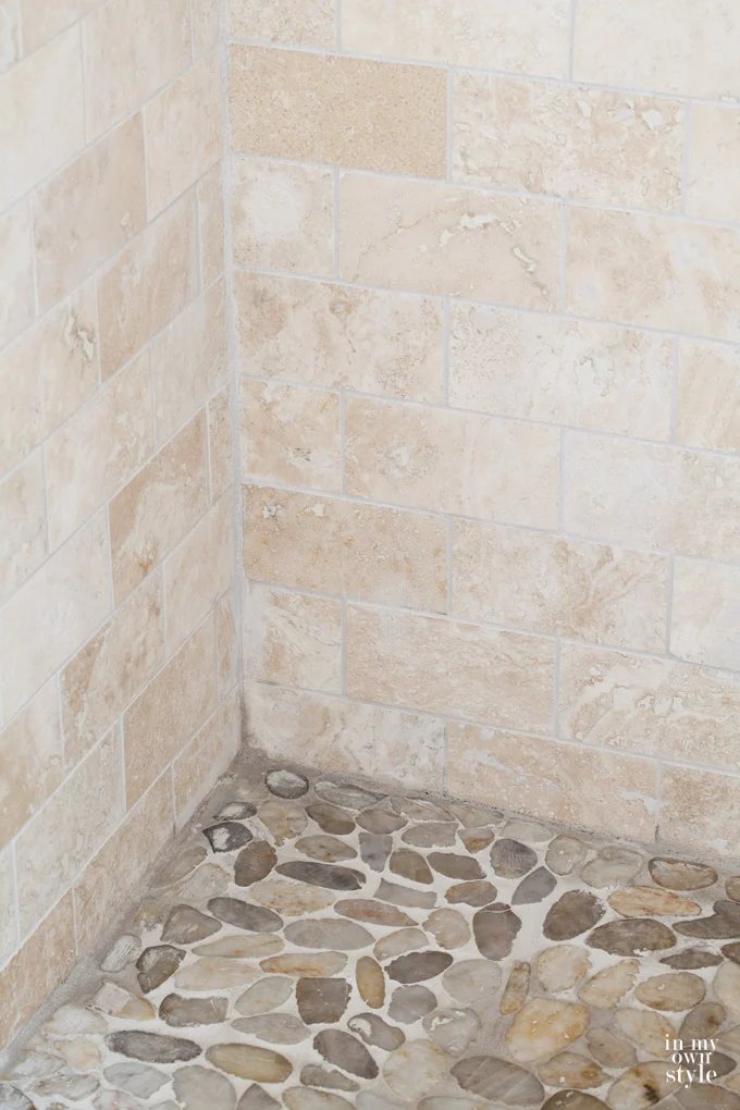 tumbled-stone tile-in-shower both on wall and floor.
