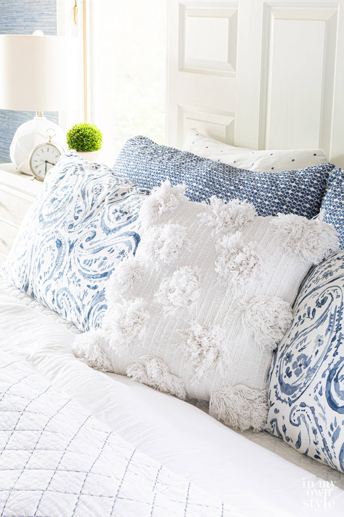 picture of pillows on a bed showing how to mix and match bedding on a bed using color, texture and pattern.