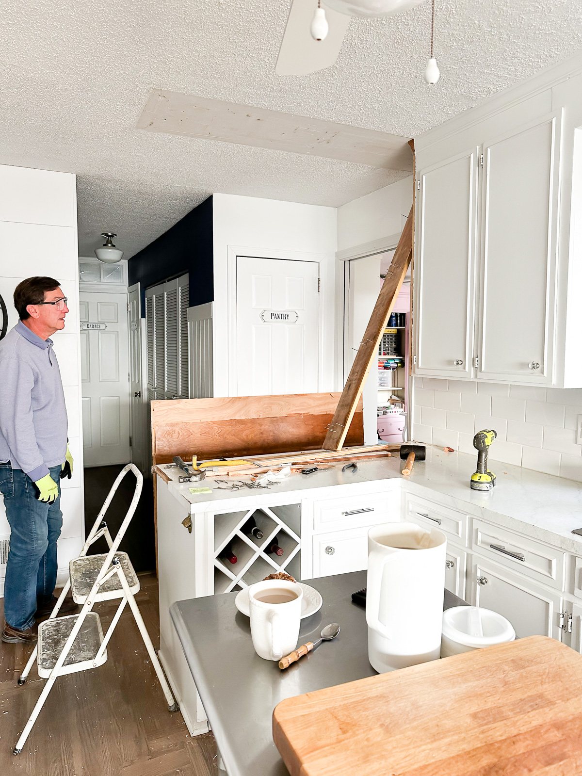 Image shows section of upper kitchen cabinet removed from wall and ceiling.
