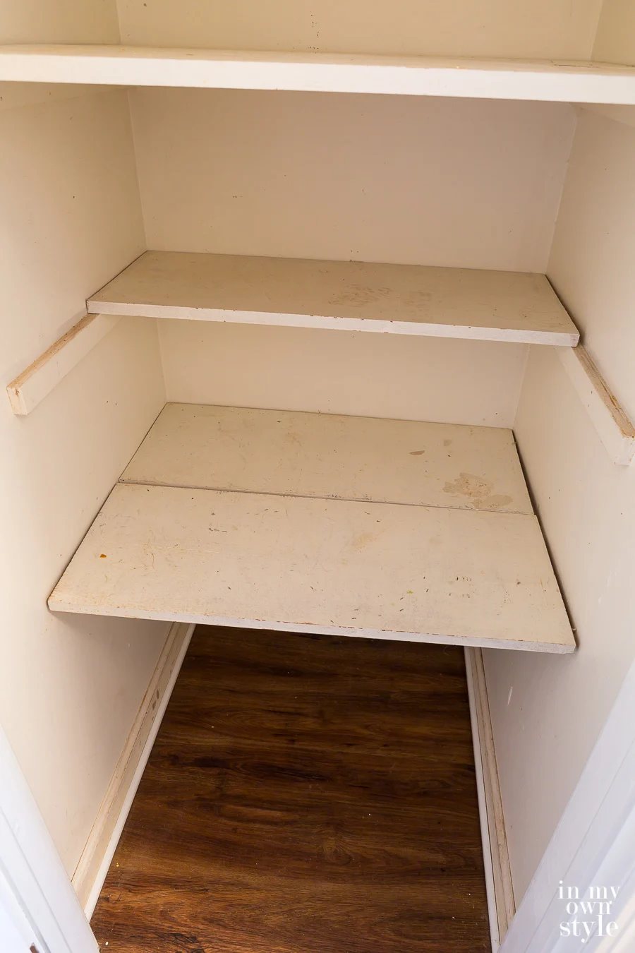 A small hall closet getting prepared for a makeover using primer and paint.