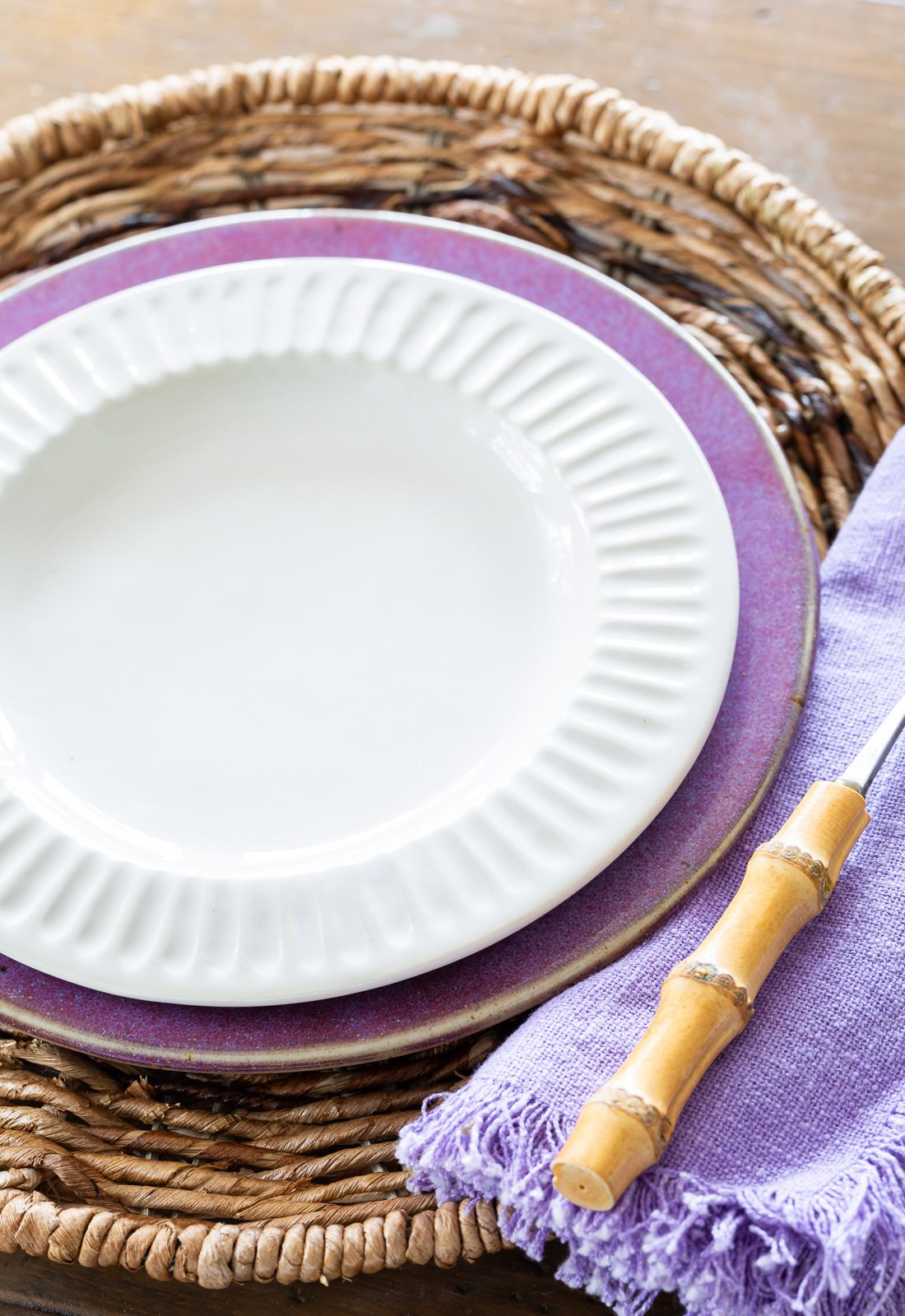 white ridged dinner plate from McGee & Co on top of a purple plate from a thrift store.