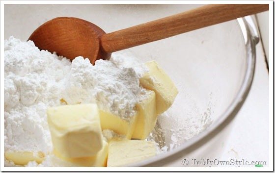 Cookies-to-make using real butter. Mixing butter and flour together in bowl.