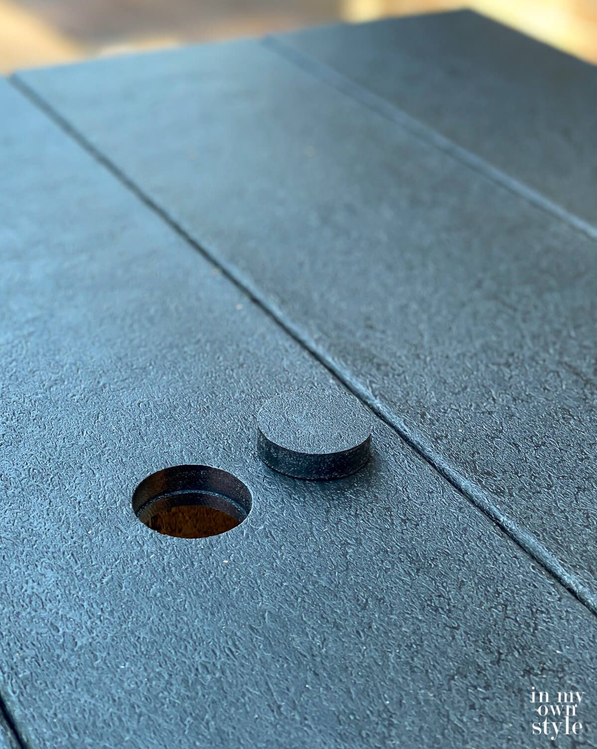Umbrella hole on table with a removable cover.