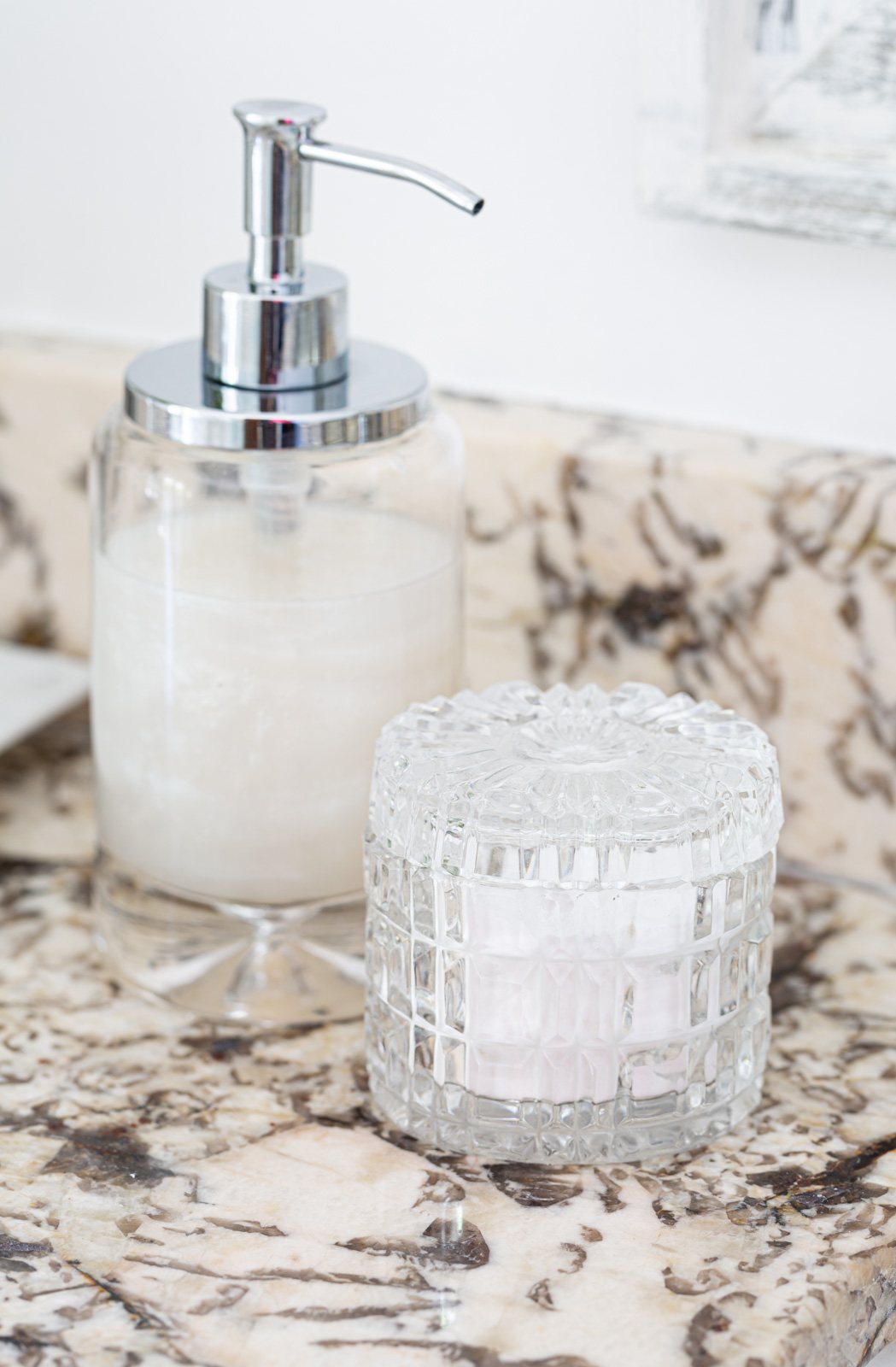 glass soap dispenser and cut crystal jar on bathroom cabinet.