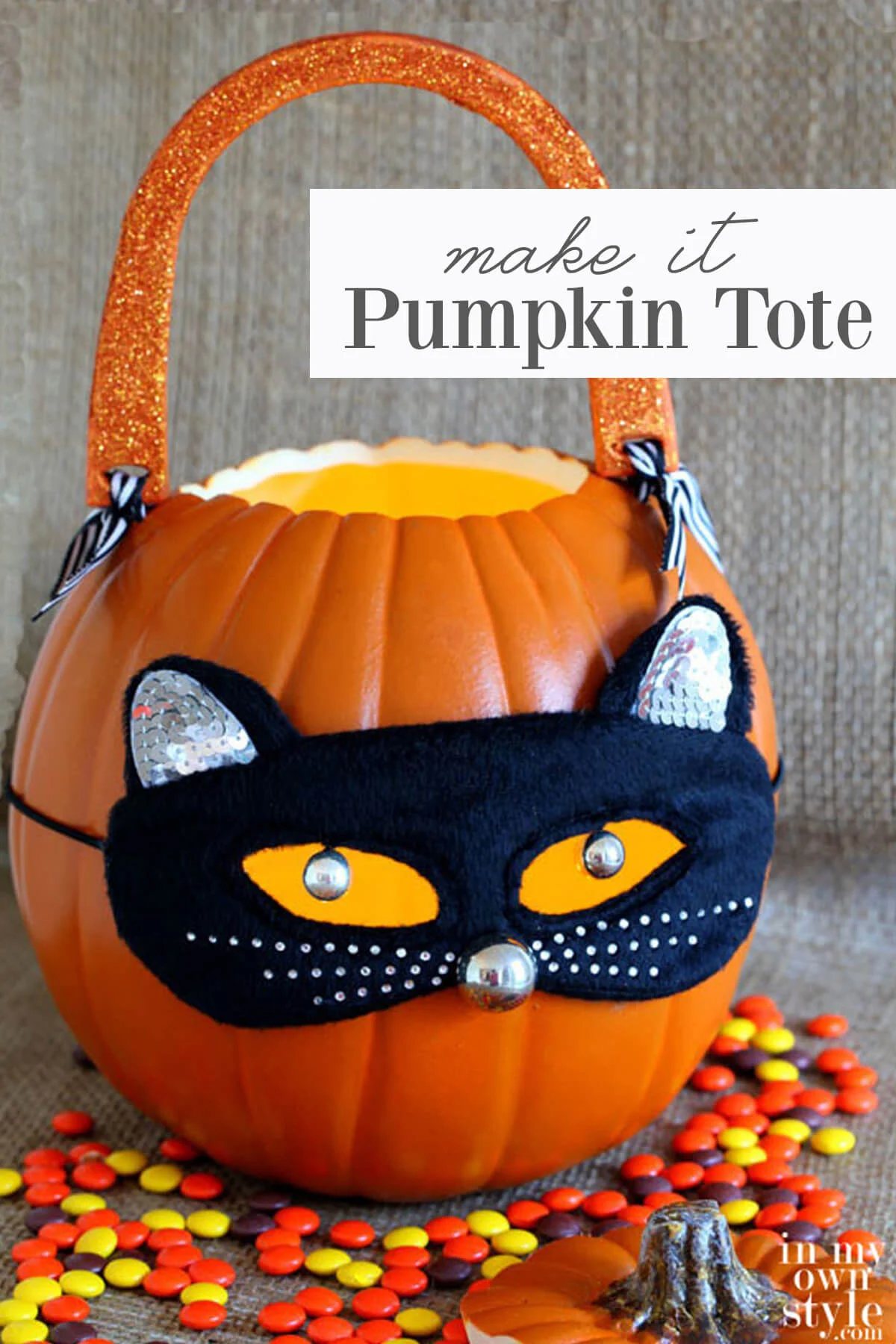 A foam pumpkin carved into a jack-o-lantern for Halloween. Black cat mask and handles were added to make into a trick-or-treating candle tote.