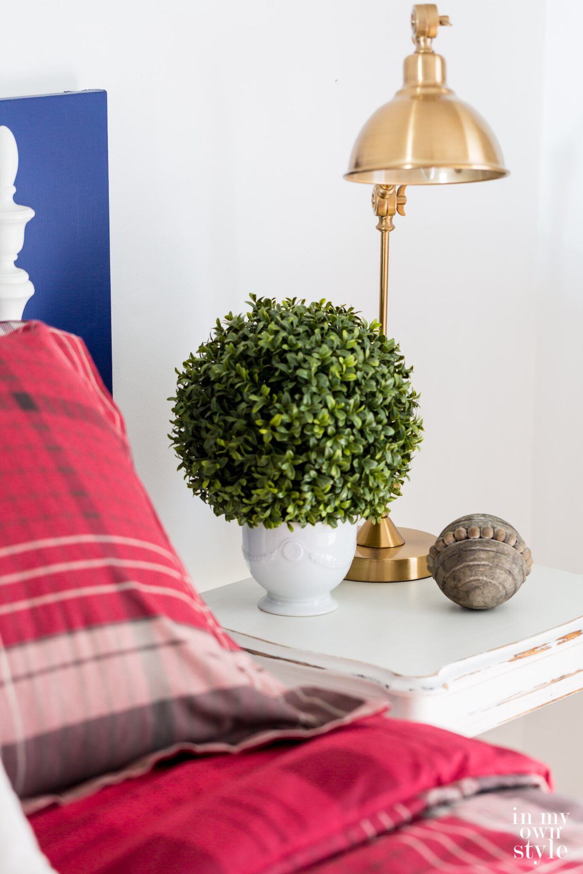 Beside table in guest room with red plaid color scheme.