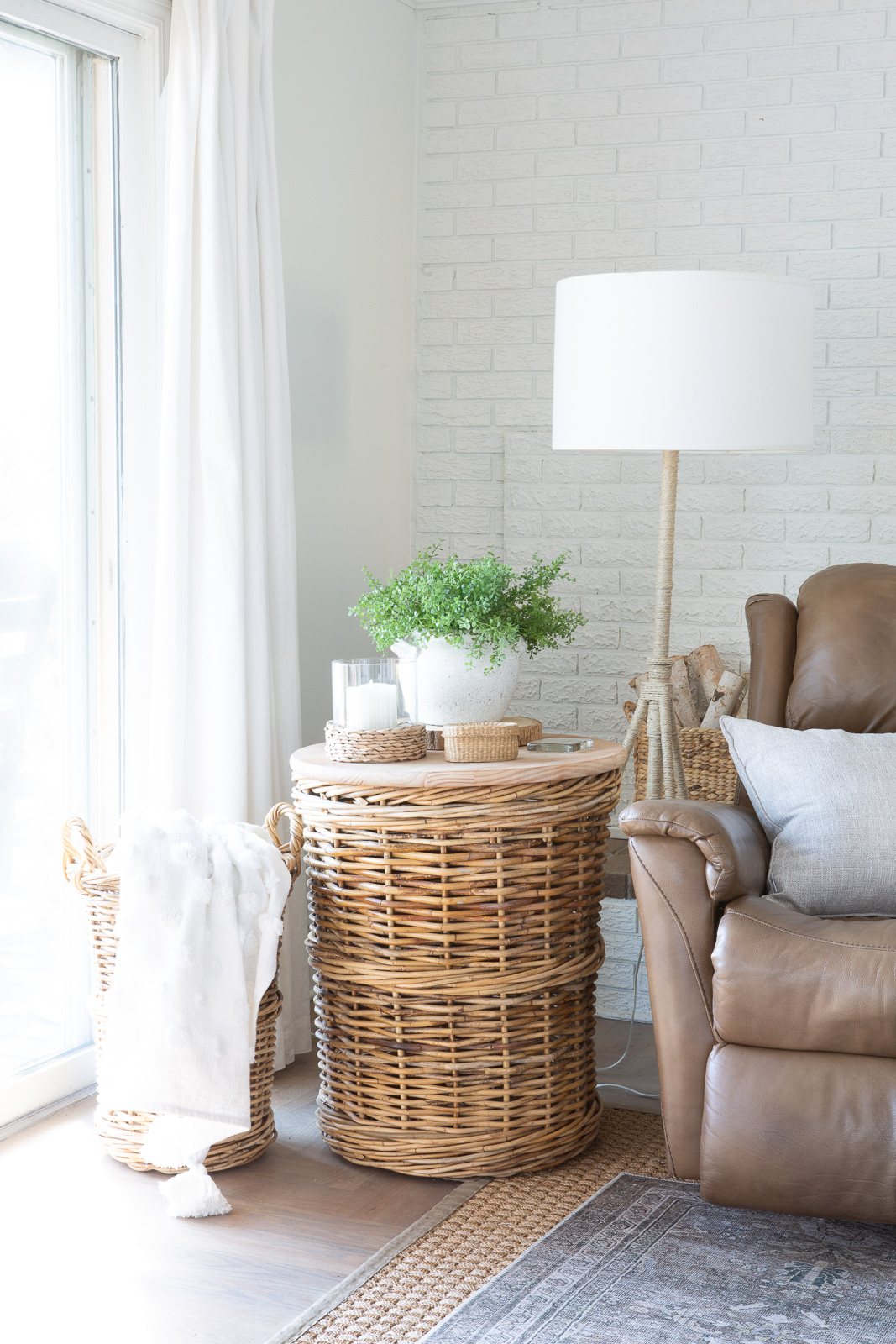 Large wicker basket made into a side table next to a driftwood colored recliner chair.