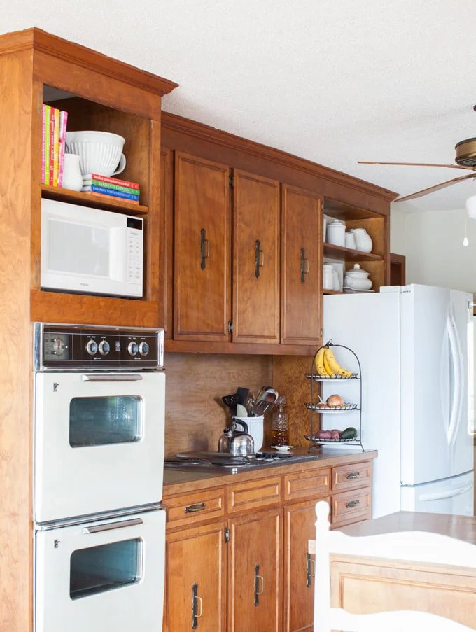 Open shelf cabinet in kitchen created by removing kitchen cabinet doors.