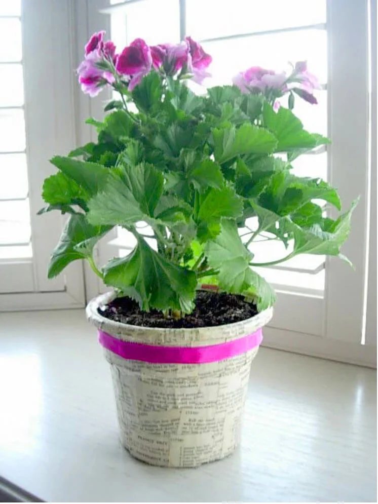 decorating a plastic planter with book pages