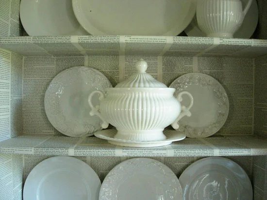 Decorating with common household items as done in this Dining room hutch that was decorated with pages from old books.