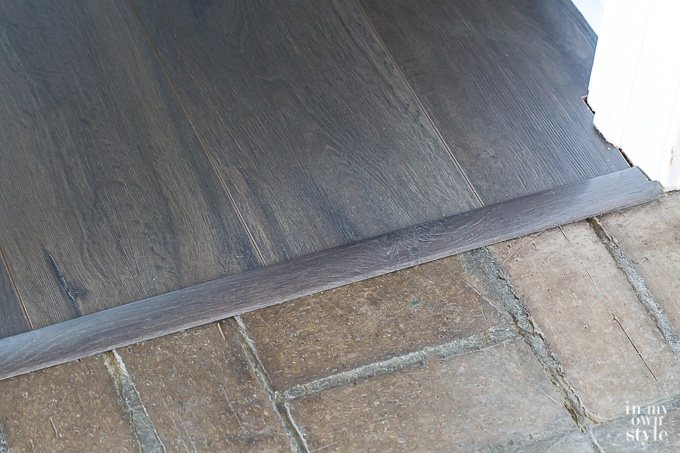 Floor molding transition strip between two different rooms.