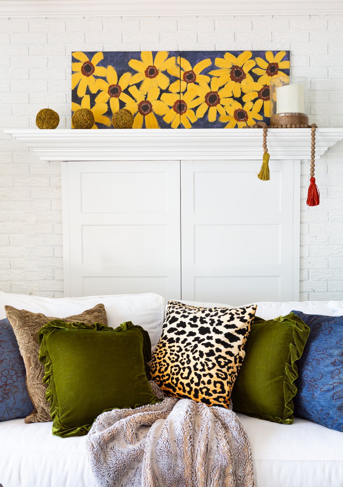 No pumpkins, mums or dried flower fall decor in a living room. Simple touches in cozy colors on a white background.