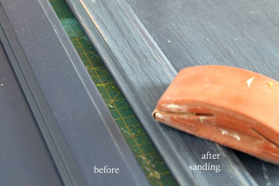 Before I put the knobs on I had to paint the cabinet first. It was navy blue. Many of you ask me how much should I sand before painting a piece of furniture. In this photo you can see that I sanded the surface just enough to scratch or rough up the surface. It took 5 minutes with a hand palm sander.
