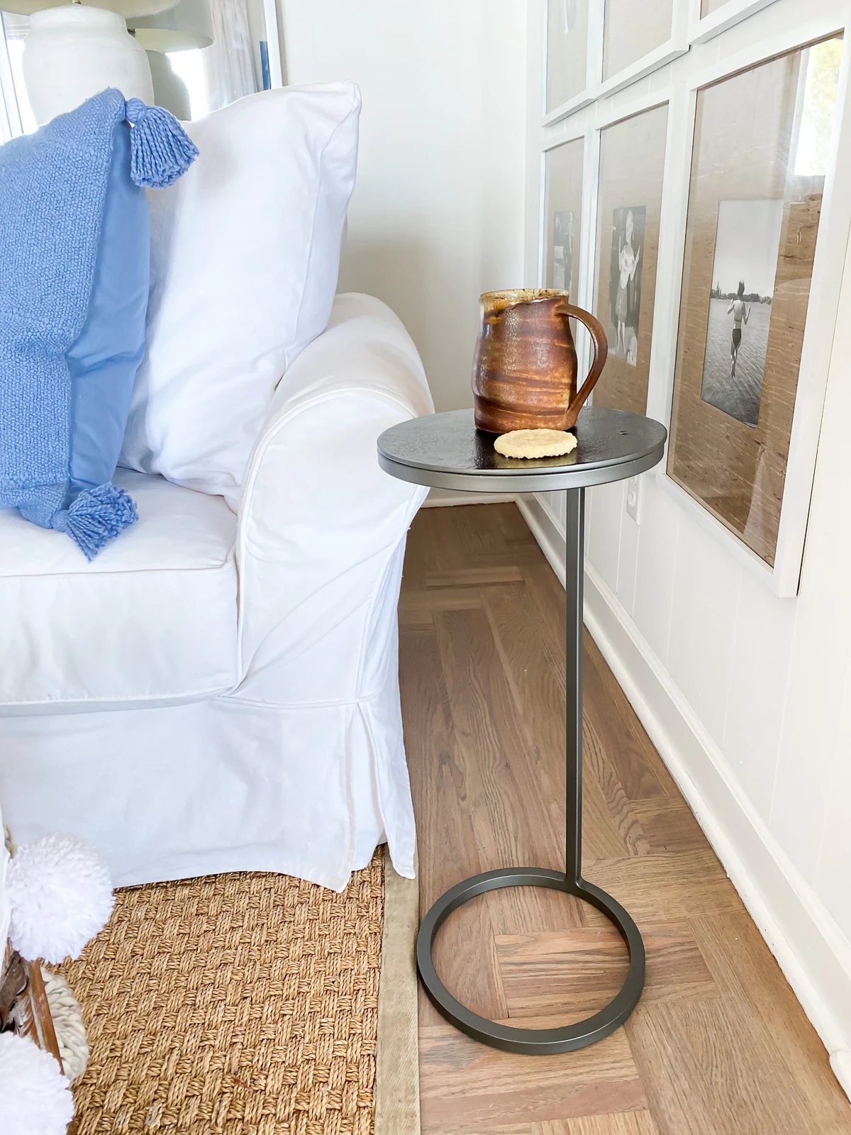 Pottery Barn Duke Round Accent table in a living room with a coffee mug on top of it.