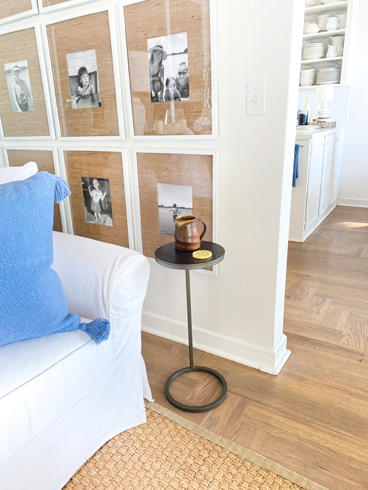 A corner in a living room with a sofa and small accent table to hold a drink.