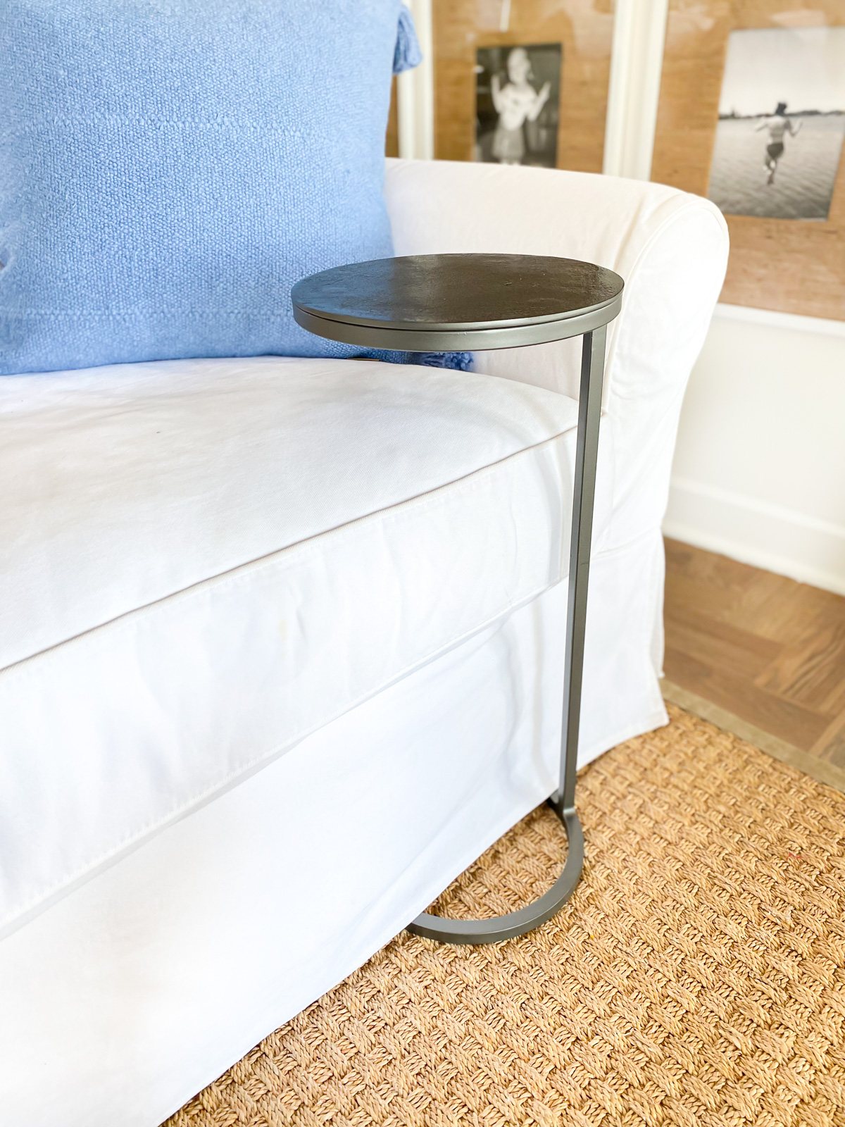 A drink table pushed under a sofa to keep a beverage close to you when sitting in a living room.