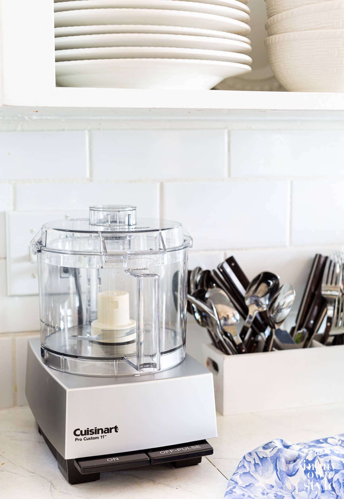 Kitchen countertop appliance organization Cuisinart Pro Custom 11 Food Processor on a counter in a small kitchen.
