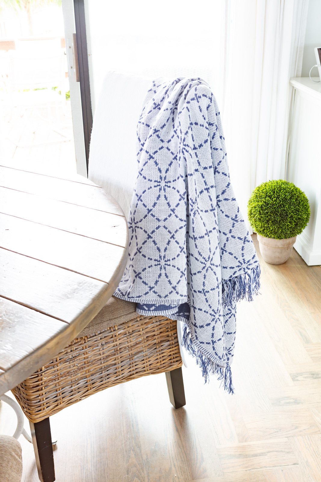 blue and white cotton throw blanket draped over a kitchen chair.