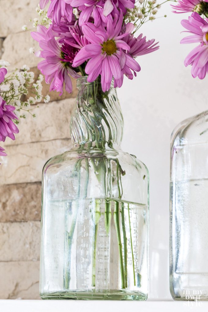 Budget friendly Spring-Mantel-decorating ideas using-recycled-glass bottles destined for the trash.