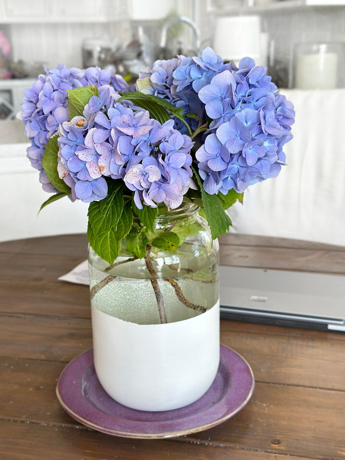 blue-hydrangeas-in-glass-vase on a table