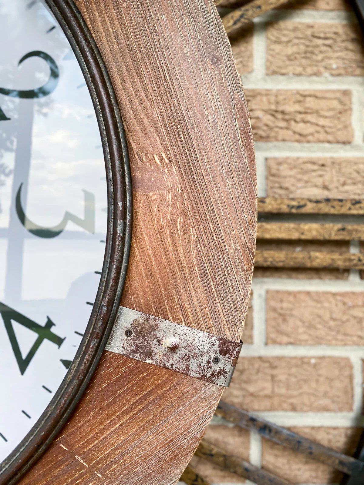 close up of wood frame on large outdoor wall clock.
