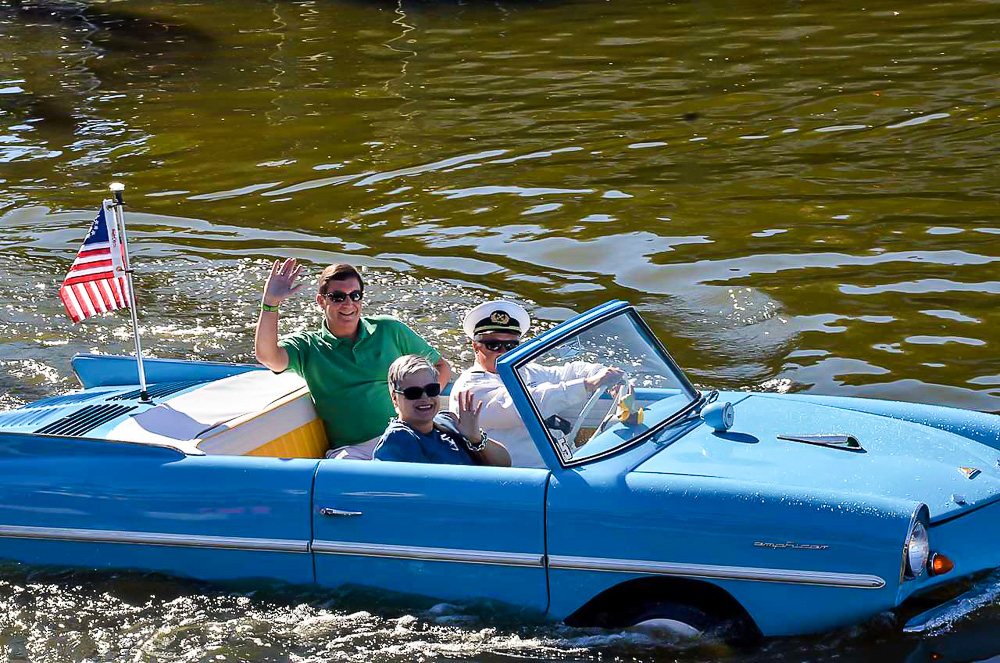 A turquoise vintage Amphicar in the lake at Disney Springs in Orlando.