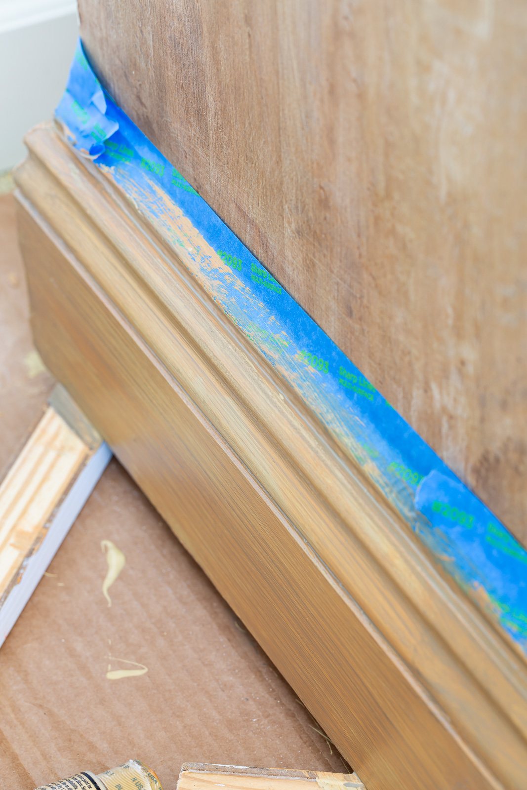 close up shot of wood cabinet and trying to match the wood grain with paint.