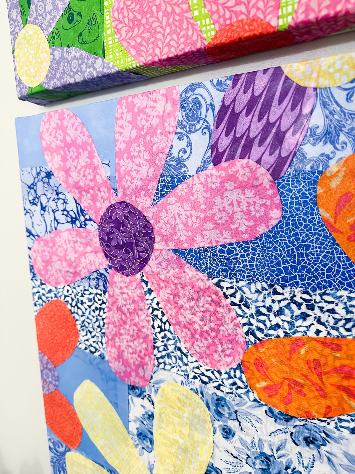 close up of colorful fabric flowers Mod Podged on a repurposed canvas