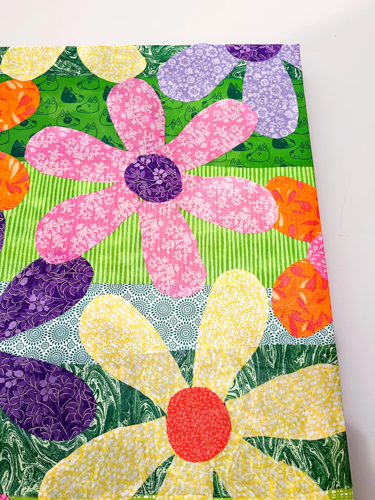 close up of colorful fabric flowers Mod Podged on a repurposed canvas