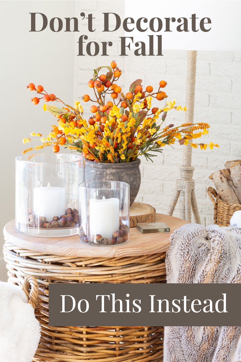 Fall flowers and candles on a wicker table. Text overlay says - Don't decorate for fall, do this instead.