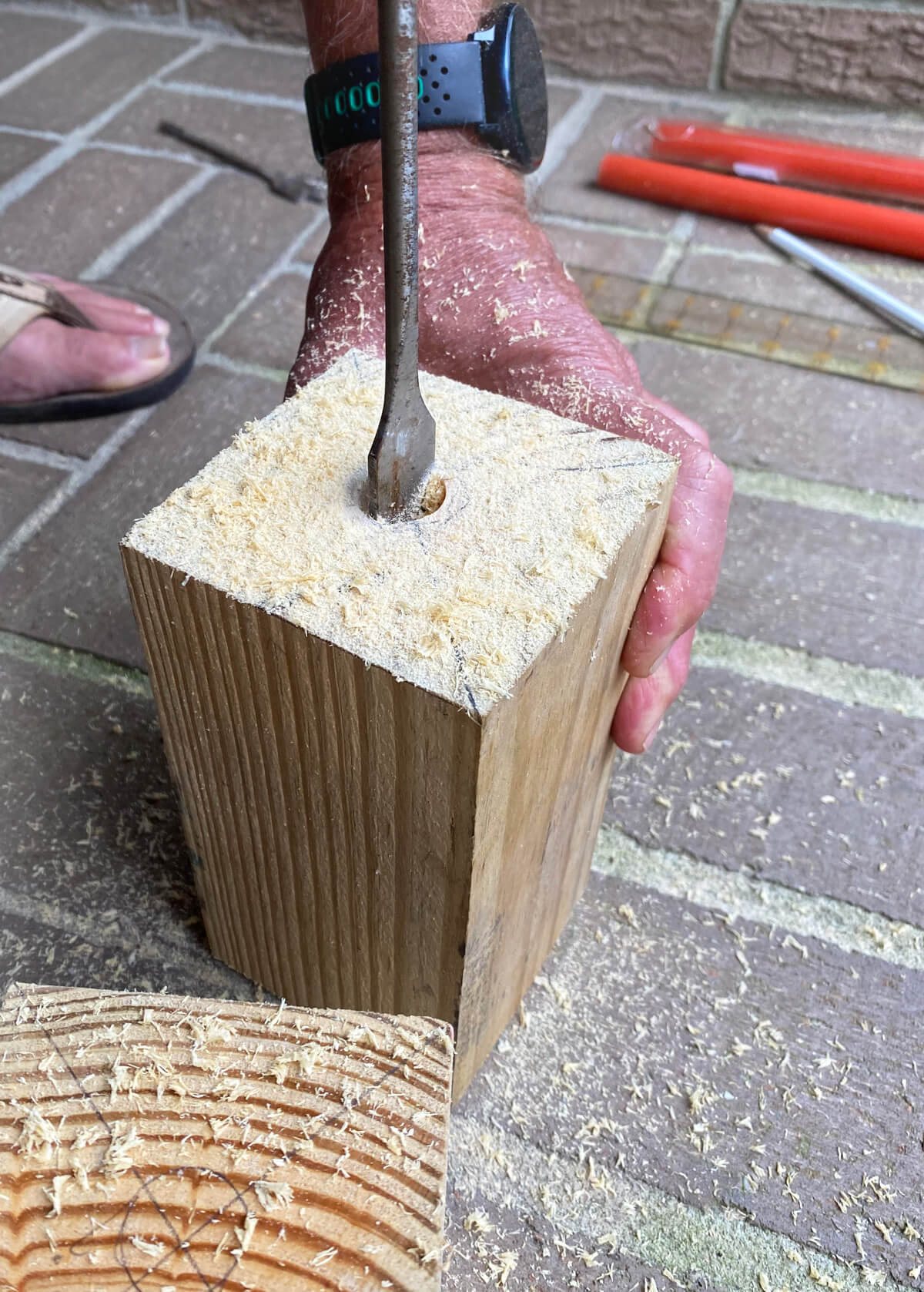 drilling hole in cut 4 x 4 post scrap of wood.