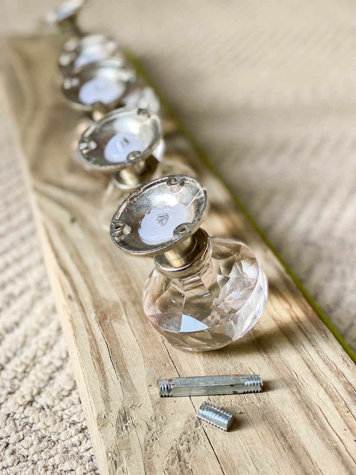 back side of glass doorknobs being ready to attach to wood board.