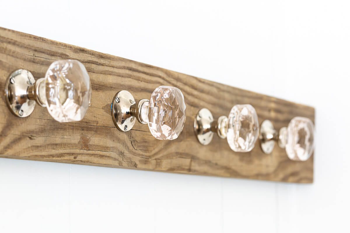 Wood board and glass doorknobs turned into a blanket holder for living room.