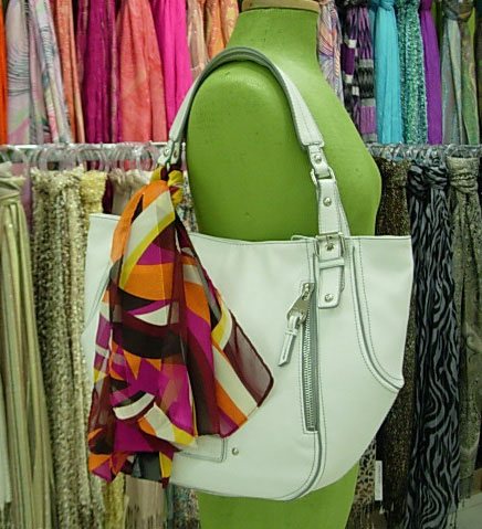 Silk scarf tied around the handle of a tote bag.