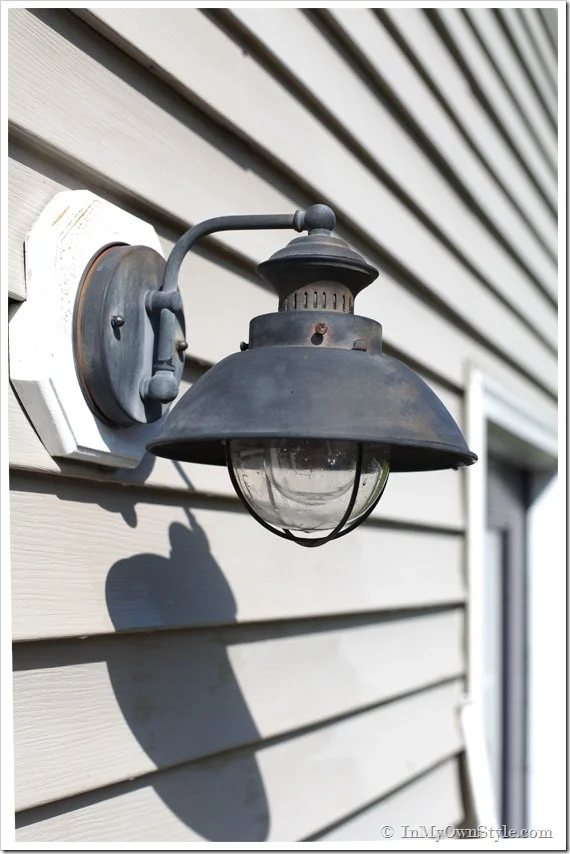 Outdoor light on side of house getting cleaned before painting.