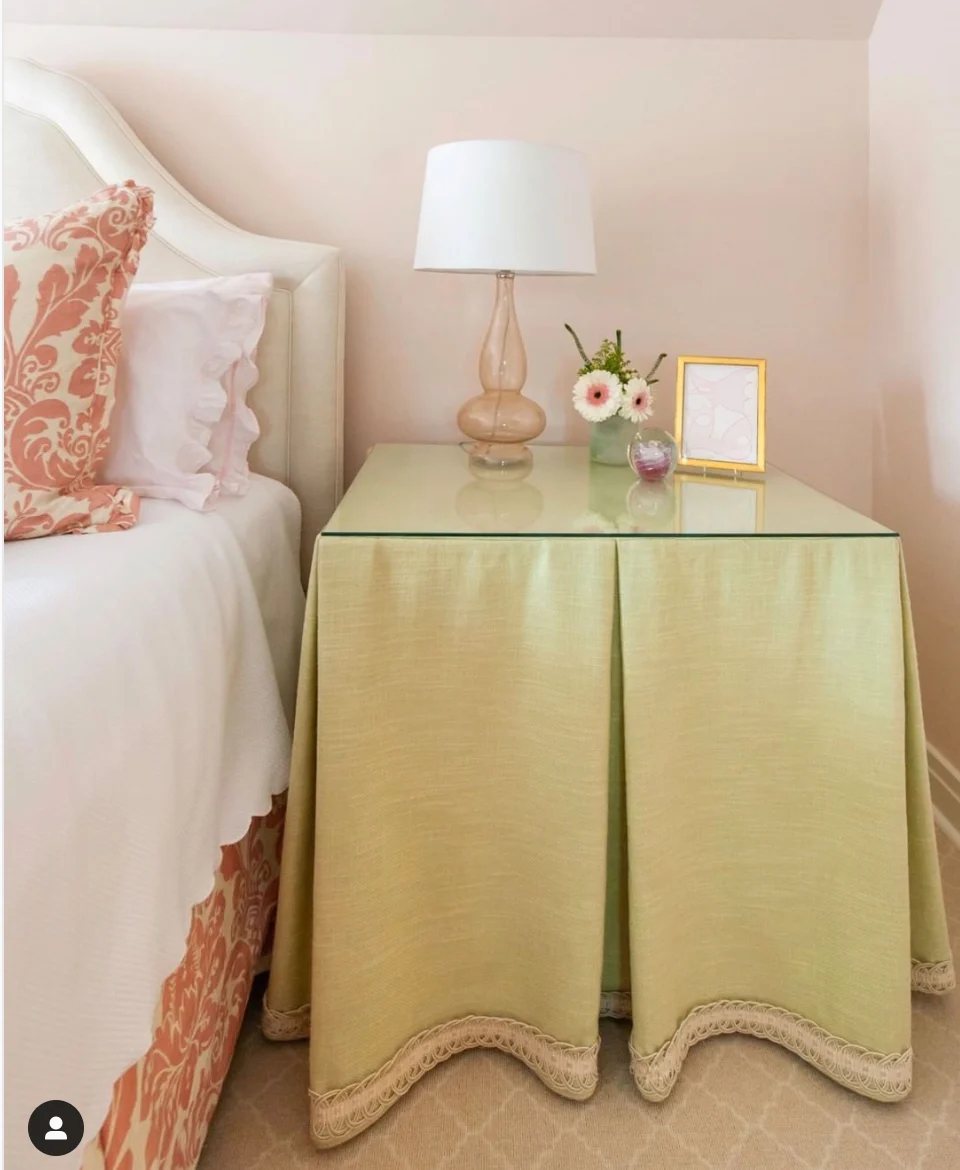 Square table with pleated skirt around it.