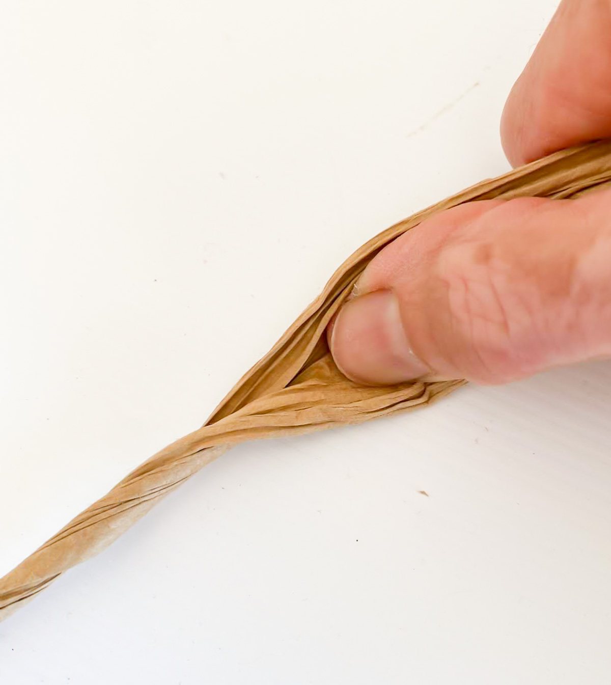 use a thumb to help untwist paper cord to turn it into ribbon