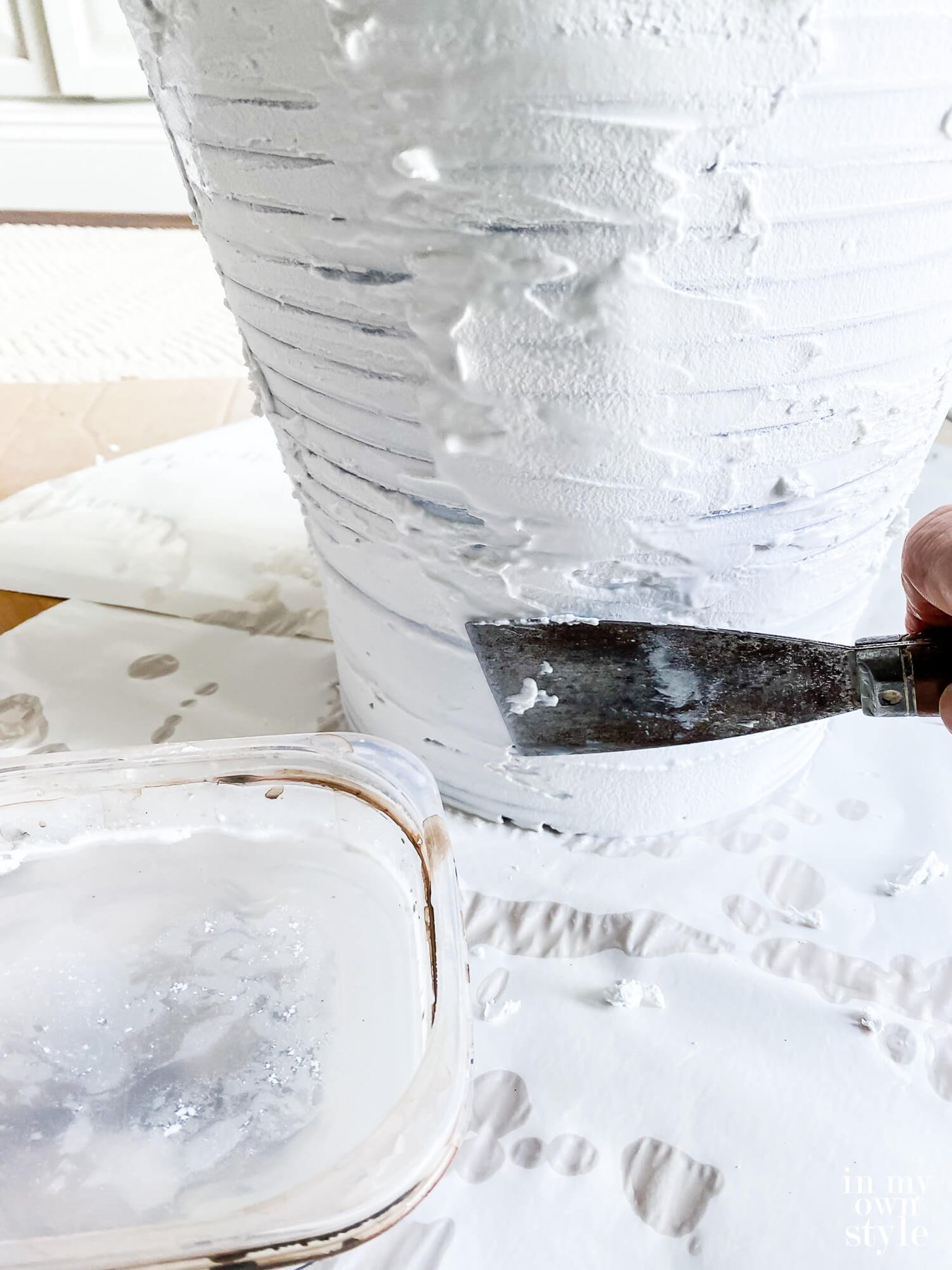 Adding a layer of Spackle to a thrift store lamp to transform it so it looks like one from Pottery Barn