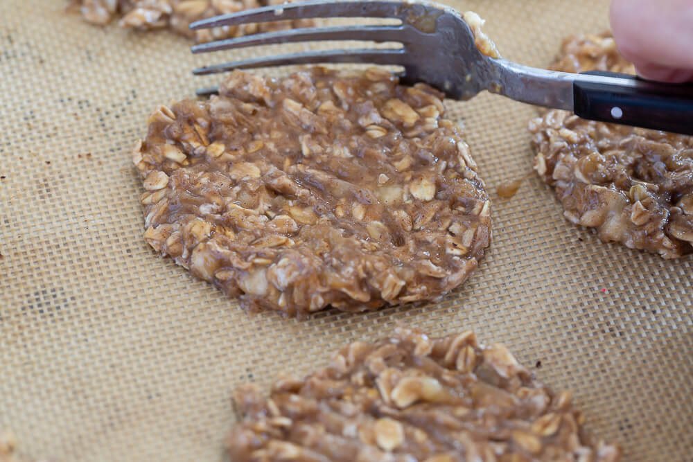 Using a fork to flatten and shape cookie on cookie sheet.