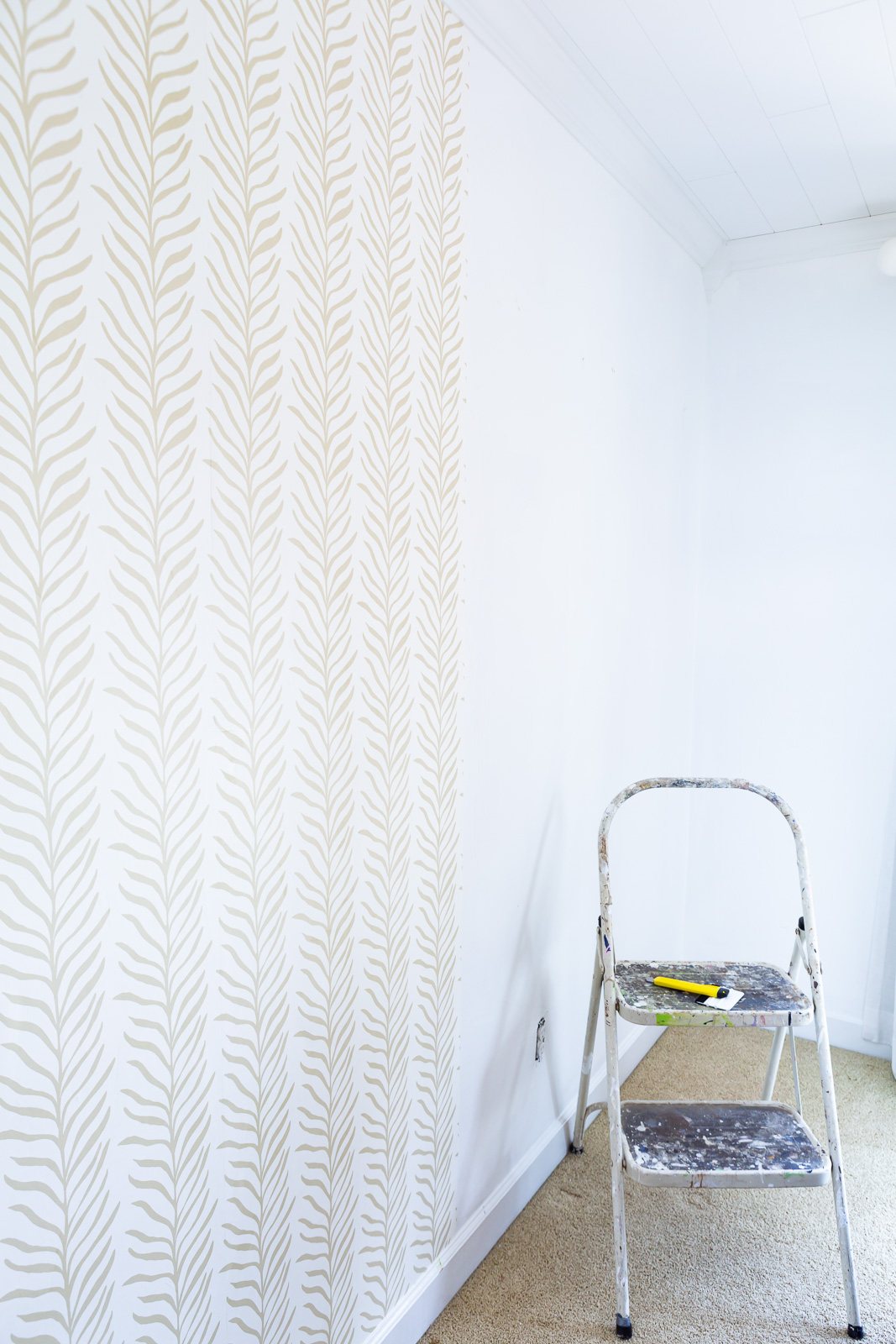 Installing panels of Love Vs Design wallpaper on a wall.
